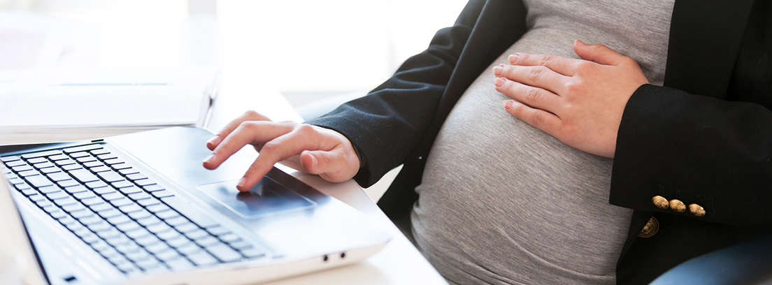 Mujer embarazada usando un ordenador