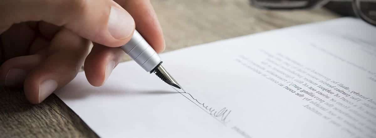Un hombre firma un documento
