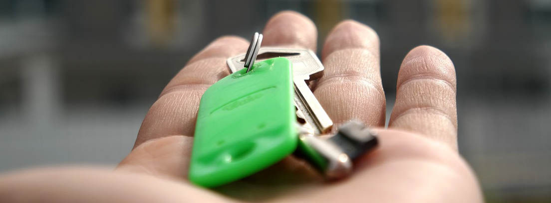 Persona con unas llaves color verde en la mano