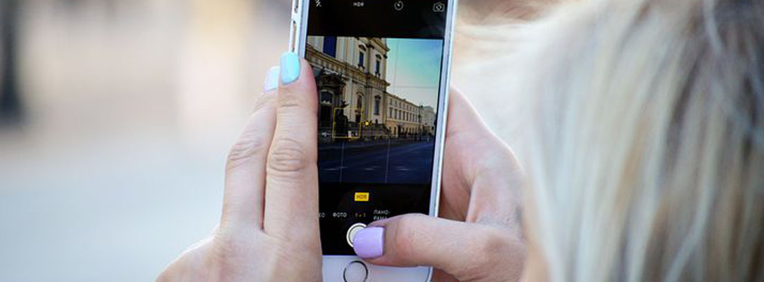 Mujer con móvil en la mano haciendo foto para subir a sus redes sociales
