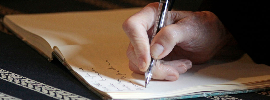 Mano con boli escribiendo en un cuaderno un testamento antes de los cambios en el impuesto de sucesiones en Andalucía