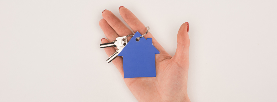 Mano mostrando un llavero azul con forma de casa