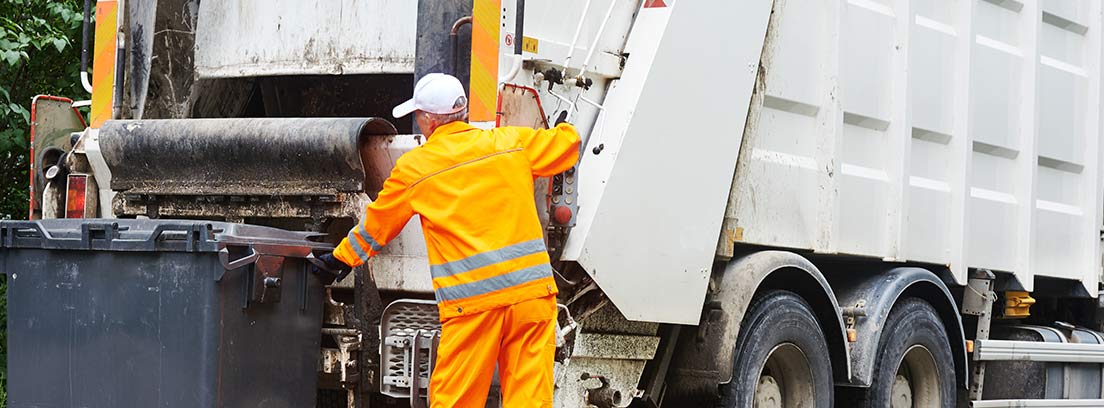 Persona con uniforme naranja junto a contenedor de basura y camión