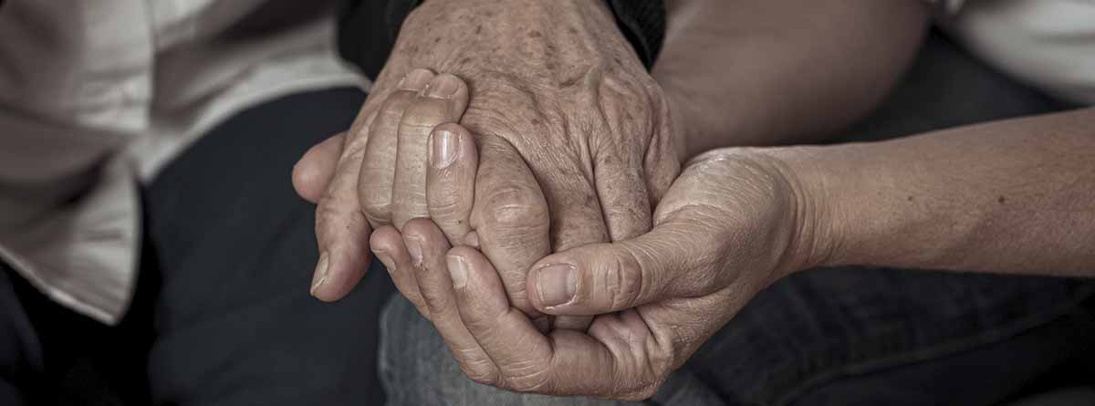 dos personas mayores dándose la mano