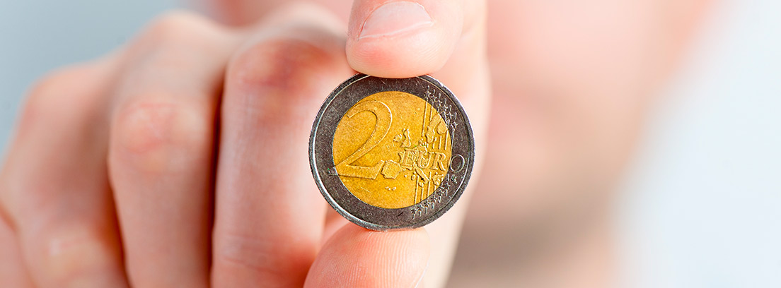 Mano sujetando una moneda de dos euros
