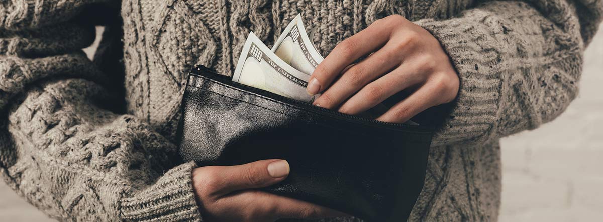 Mujer guardando unos billetes en una cartera