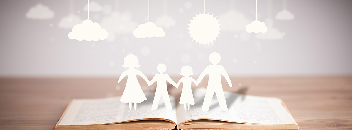 Figuras de cartón de una familia sobre un libro abierto