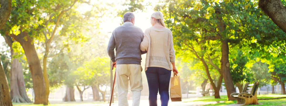 mujer y hombre jubilados dando un paseo por el parque